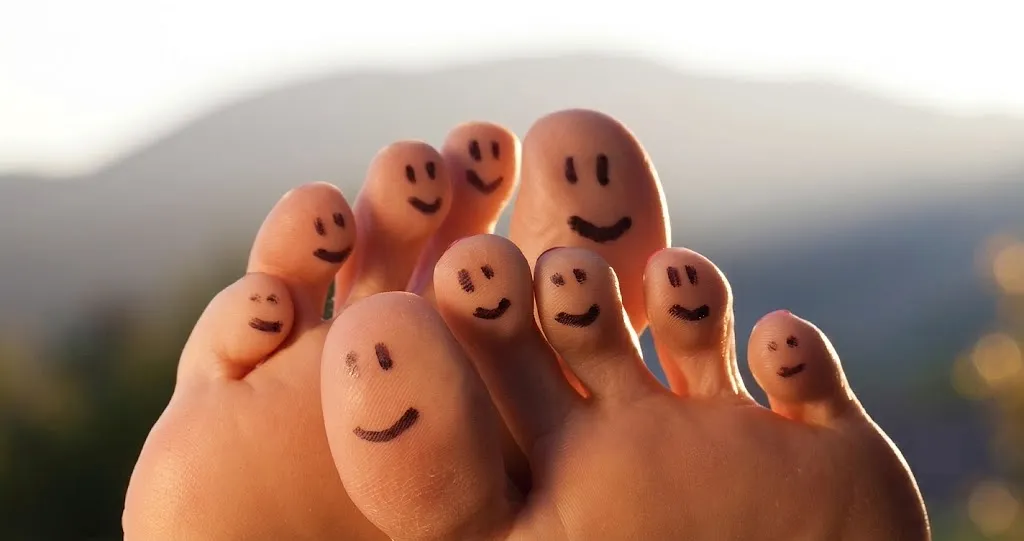 Two bare feet with happy smiley faces drawn on the toes, illustrating optimal foot health in Southeast Asia as discussed in The Reyneker Guide.